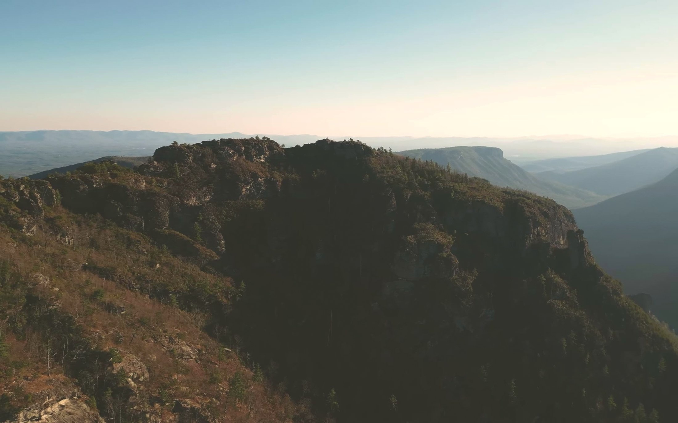 Forested Blue Ridge peak and distant mountain layers under a pale sky near Asheville, North Carolina
